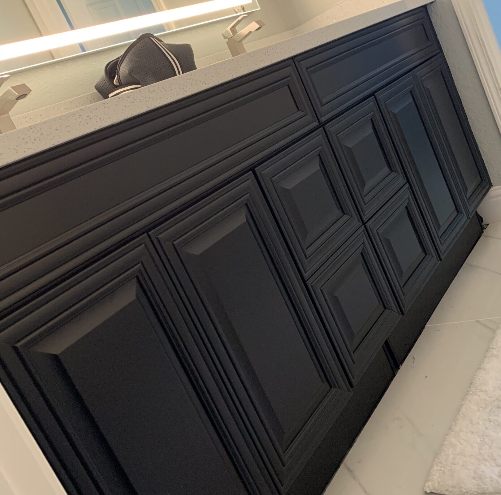 "An image showing black painted cabinets in a room, featuring sleek and modern design with a smooth and glossy finish."